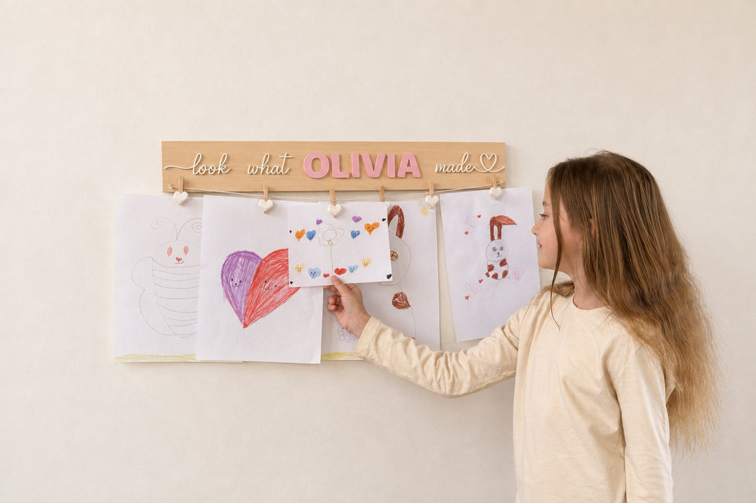 Child displaying artwork on a personalized Look What I Made sign with the name Olivia.