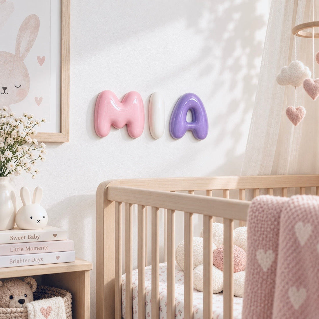 Glossy pink, white and purple MIA bubble letters styled on a nursery wall.