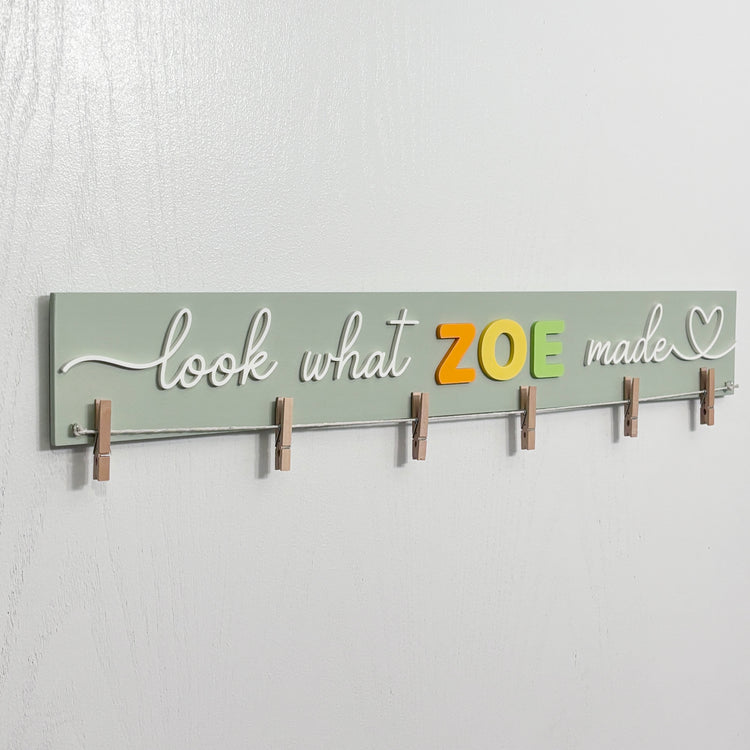 Close-up of personalized wooden art display board with mini clothespins for kids artwork
by The Homenko Studio, Calgary, Canada