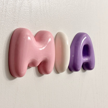 Personalized 3D bubble letters spelling MIA in glossy pink, white and purple on a nursery wall
by The Homenko Studio, Calgary, Canada