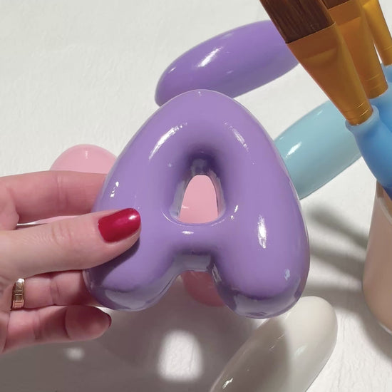 Video showing the rounded shape and glossy finish of purple and pink 3D bubble letters